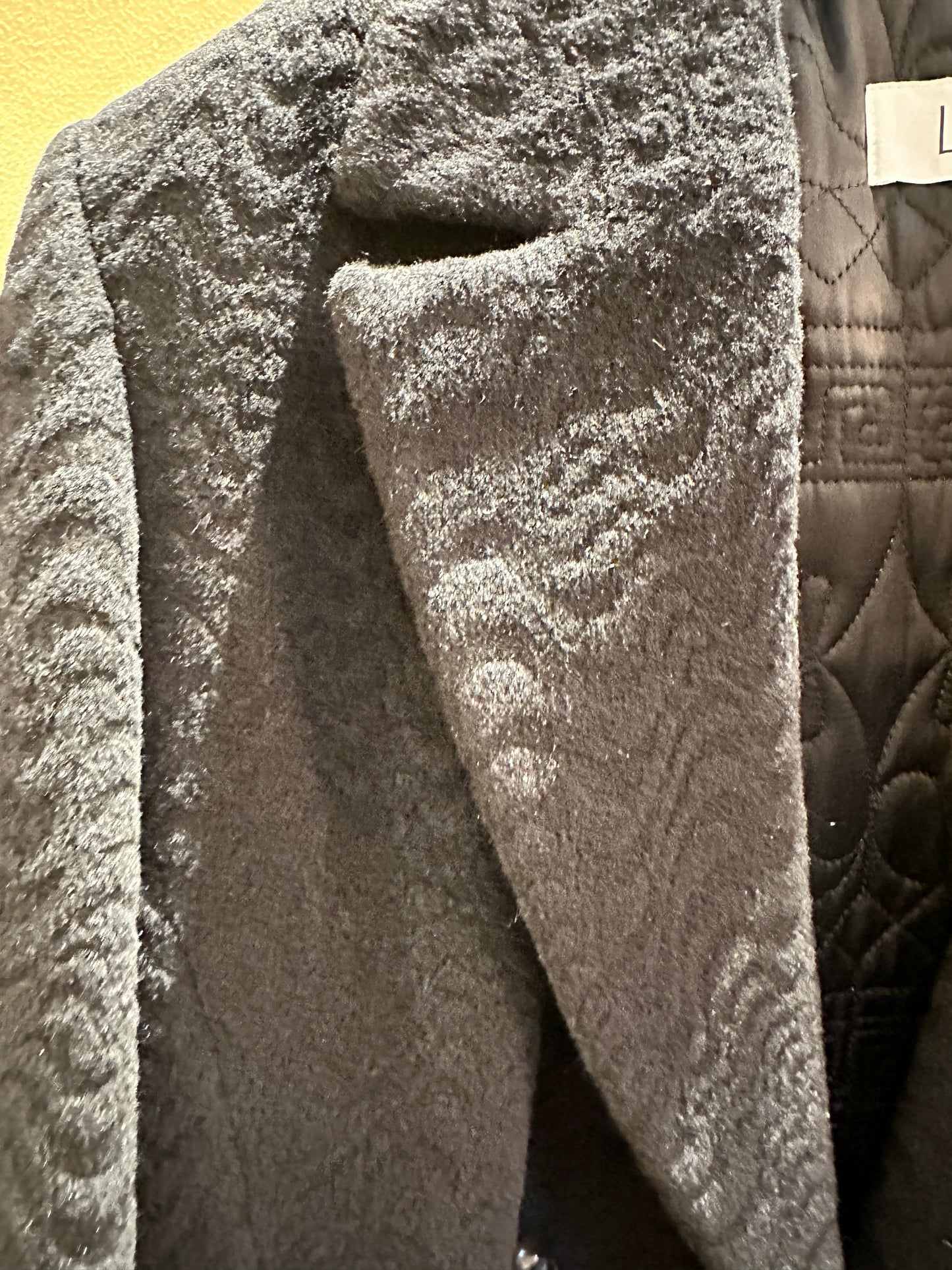Close-up of the luxurious Laurel Black Long Coat featuring a wavy pattern and elegant mandarin collar.