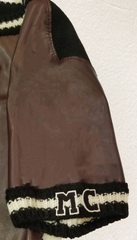 Close-up of a Marccain leather blouse sleeve featuring cozy knitted trim and distinctive logo detail.