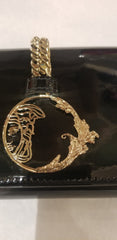 Close-up of Versace clutch featuring a black finish and ornate gold design, showcasing luxury and style.