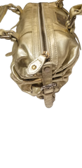 Close-up view of a luxurious Versace gold handbag featuring stylish zippers and detailing.