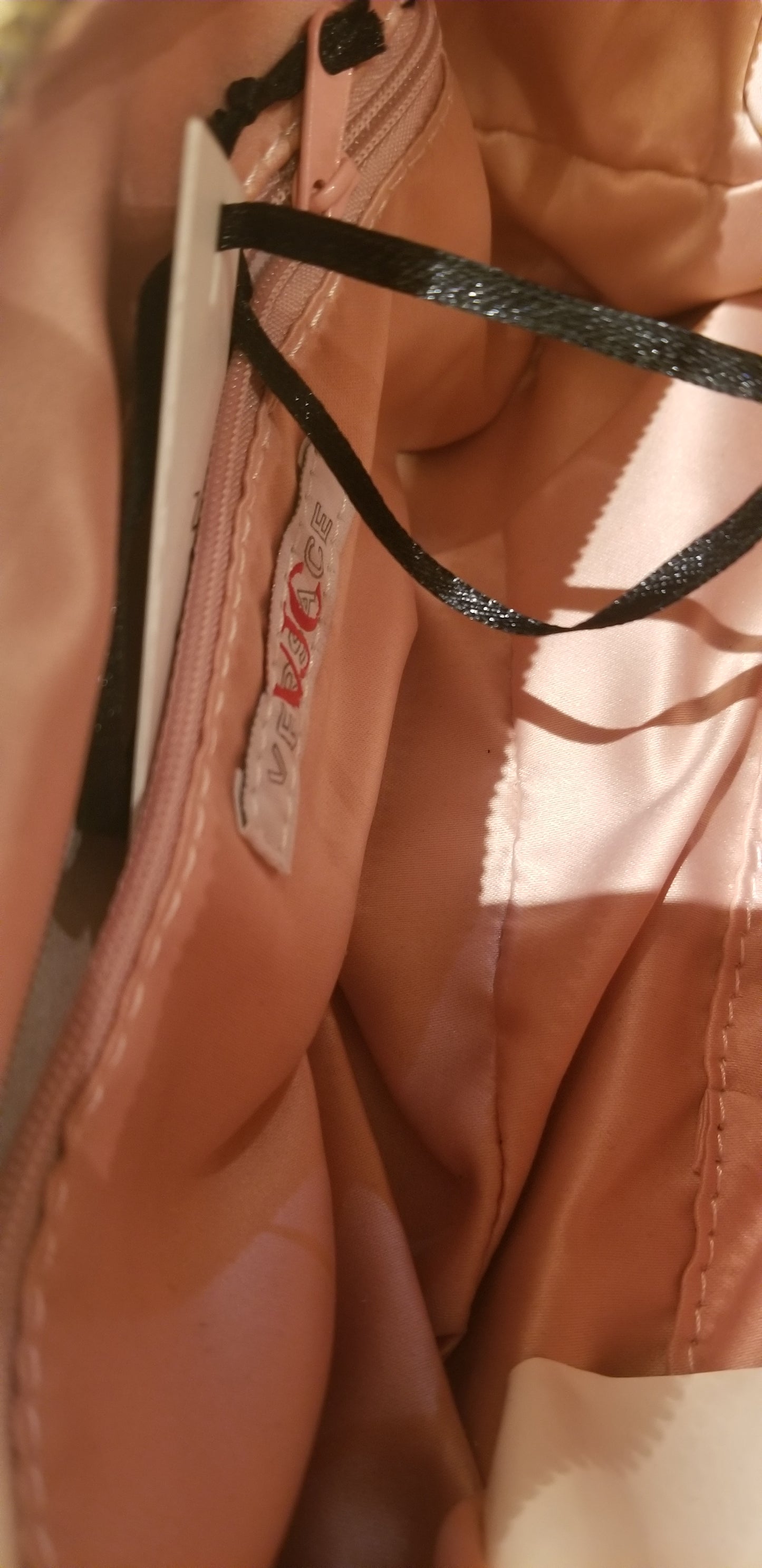 Interior view of a Versace gold handbag showcasing its elegant lining and design details, ideal for luxury fashion enthusiasts.
