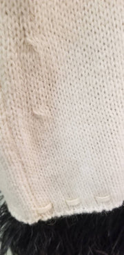 Close-up of the creamy white fabric texture of the Laurel Sweater, showcasing its fine knit and detailing.