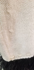 Close-up of the creamy white fabric texture of the Laurel Sweater, showcasing its fine knit and detailing.