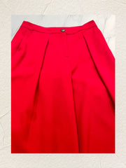 Close-up view of Marccain red flared pants showcasing pleats and button detail, made from triacetate and polyester blend.