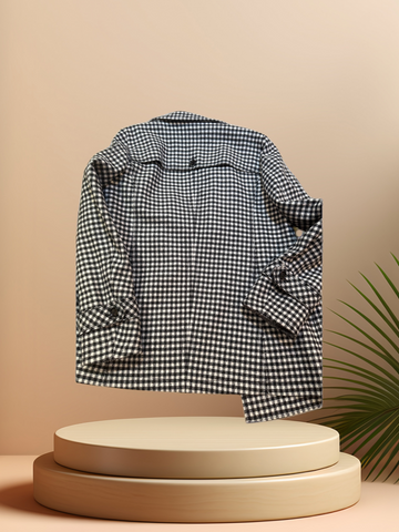 Marccain black and white checked coat displayed on a pedestal, showcasing its stylish design and cozy fabric.