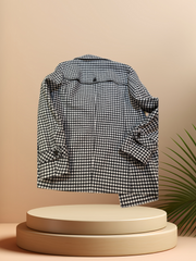 Marccain black and white checked coat displayed on a pedestal, showcasing its stylish design and cozy fabric.