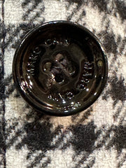 Close-up of Marccain black and white checked coat button, showcasing quality craftsmanship and design details.