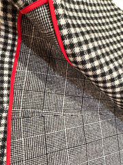 Close-up of the Marccain black and white checked coat fabric with red piping, showcasing its stylish texture and quality.
