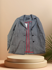 Marccain black and white checked coat showcasing stylish design and quality fabric on a minimalist display.