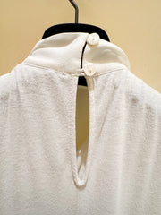 Back view of Seventy Blouse in creamy fabric with button closure and keyhole cutout, made from 70% viscose and 30% lana wool.