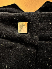 Close-up of Versace pants fabric with gold logo detail, showcasing premium quality and stylish design.