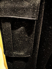 Close-up of Versace Pants fabric showing moderated pocket detail in a sleek, black finish.