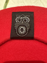 Close-up of intricate insect beading decoration on a red wool beret from Seventy Berets.