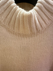 Close-up of the creamy white Laurel Sweater, featuring a ribbed neckline and soft texture, perfect for winter style.