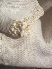 Close-up of the creamy white Laurel Sweater showcasing its soft knit texture and unique sleeve design.