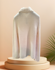 Back view of the creamy white Laurel Sweater on a display with a modern backdrop, perfect for winter wear.