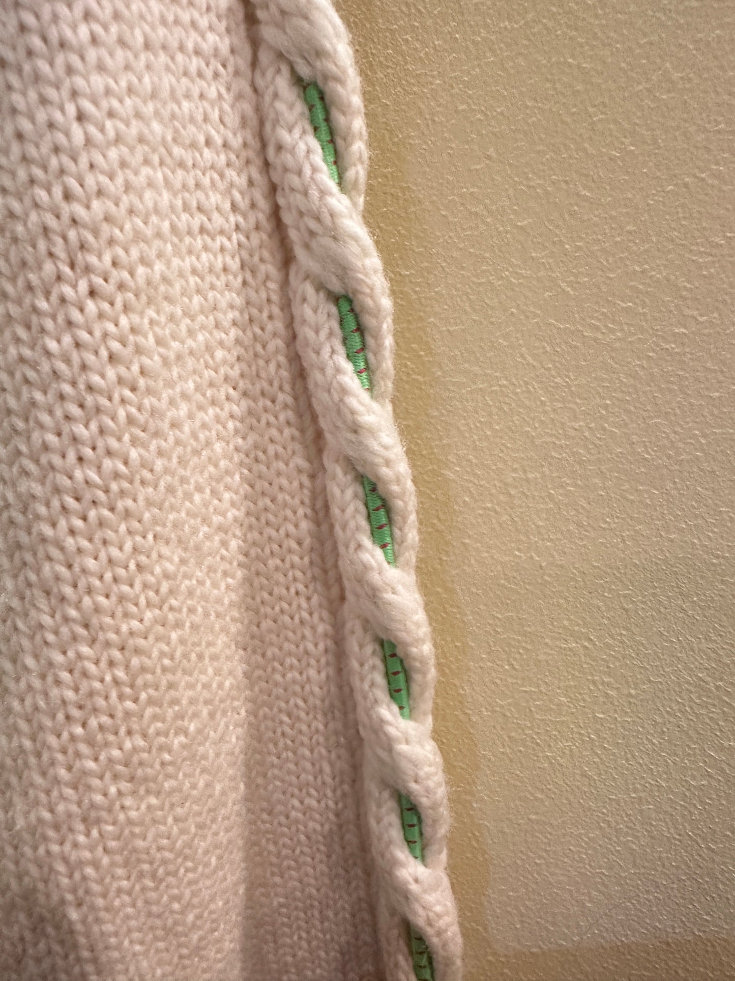 Close-up of Versace White Sweater featuring a green thread braid detail along the sleeve.