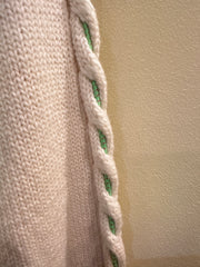 Close-up of Versace White Sweater featuring a green thread braid detail along the sleeve.
