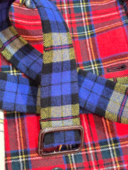 Close-up detail of a Moschino tartan coat featuring colorful plaid fabric and a stylish buckle.