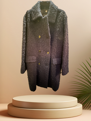Marccain black long coat displayed on a pedestal, featuring a unique textured fabric, perfect for winter fashion.