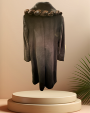 Mallia black fur braid collar long coat displayed on a pedestal with a warm background.