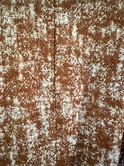 Close-up of cozy textured fabric with a blend of brown and white patterns, ideal for stylish outerwear.