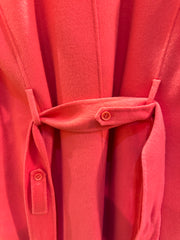 Close-up of Marccain coral red long coat showing fabric texture and belt detail for a stylish look.