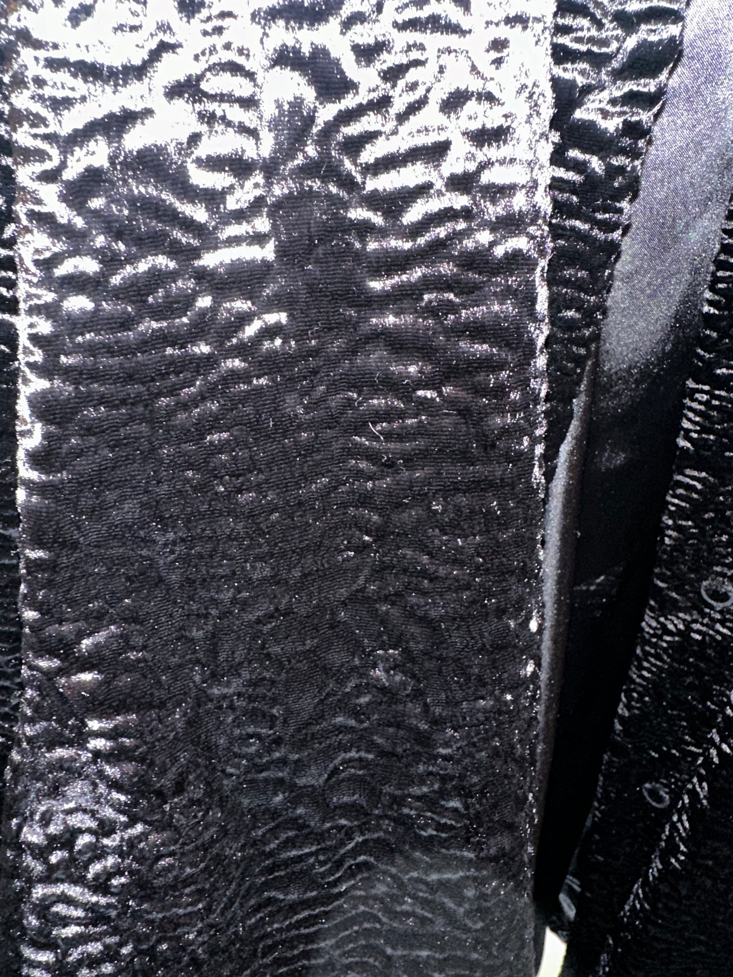 Close-up of Novelti Black Long Coat showing its unique shiny wavy texture, perfect for stylish warmth.