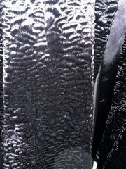 Close-up of Novelti Black Long Coat showing its unique shiny wavy texture, perfect for stylish warmth.