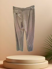 Marccain Checked Straight Pants made of luxurious 98% virgin wool, displayed elegantly on a pedestal with a leaf backdrop.