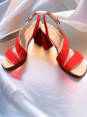 Marccain suede sandals in orange, featuring chunky heels for comfort and style, elegantly displayed on soft fabric background.
