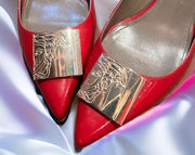 Versace red kitten heels with gold accents, showcasing style and elegance on satin background.