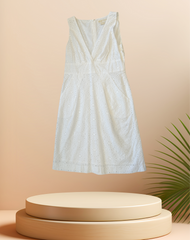 Elegant white summer dress displayed on a pedestal with a minimalistic background, showcasing stylish design and comfort.
