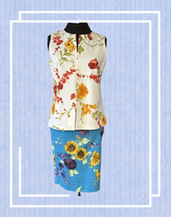Derrico White Floral Blouse featuring colorful floral designs paired with a vibrant blue floral skirt on a mannequin.
