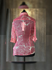 Versace silk shirt in pink with rose design, showcasing elegant back view on mannequin display.