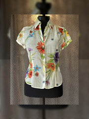 Escada silk shirt featuring a vibrant floral design perfect for summer, combining comfort and elegance.
