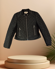 Michael Kors leather jacket on display, featuring quilted design and silver nail decorations, perfect for stylish spring wear.