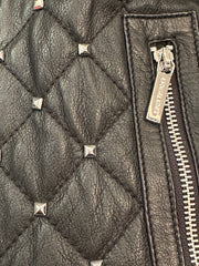 Close-up of Michael Kors leather jacket showcasing quilted texture and silver nail decorations.