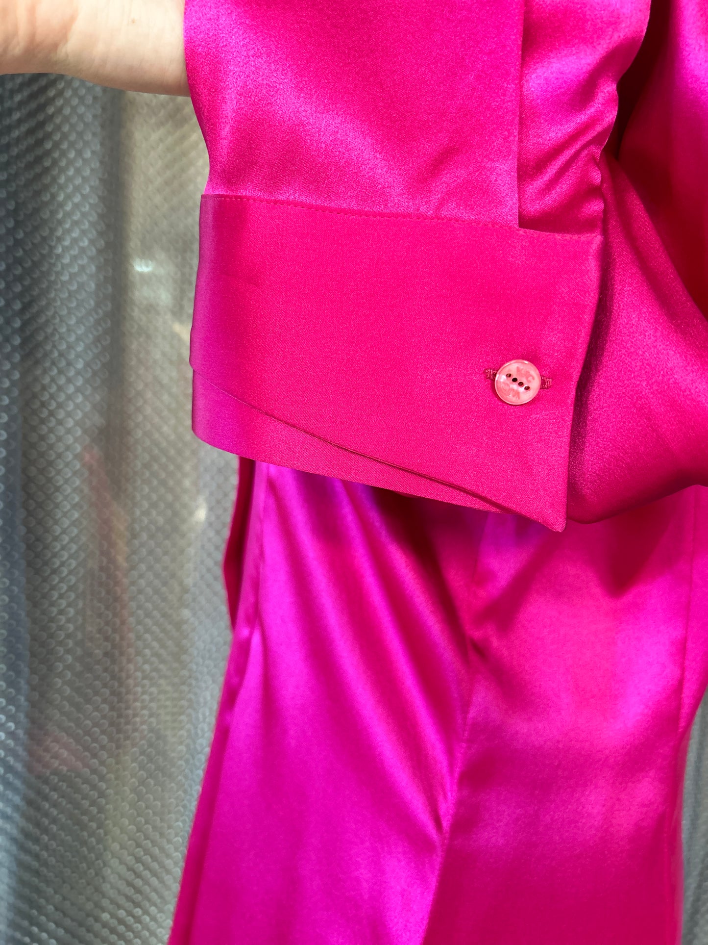 Close-up of the cuff and button detail of a luxurious Versace Silk Hard Pink Shirt.