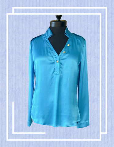 Versace silk shirt in blue displayed on a mannequin, showcasing luxurious fabric and elegant design.