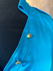 Close-up of Versace silk shirt collar showing luxurious blue fabric and stylish gold buttons.