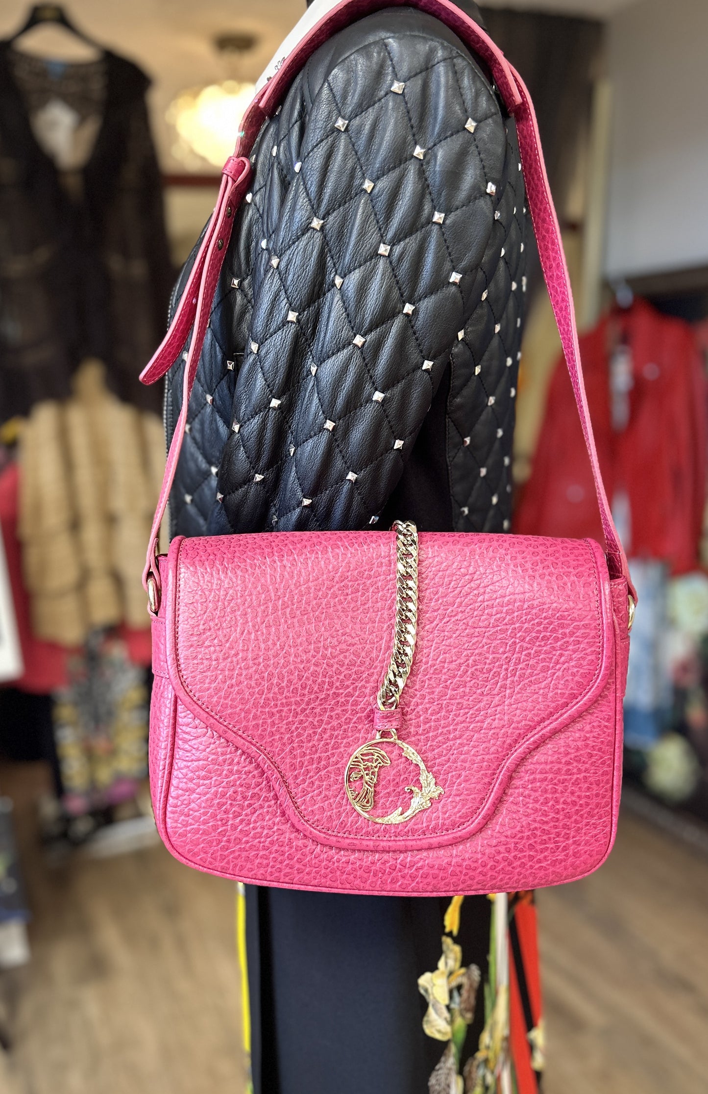 Versace pink leather bag with chain detailing and adjustable strap, perfect for stylish accessorizing.