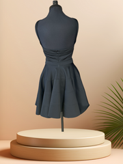 Versace Black Dress showcasing a low cut back, stylish strip sleeves, and feminine circular skirt on a mannequin.