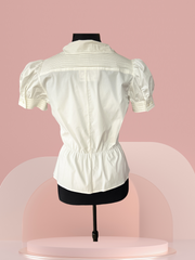 Pennyblack White Blouse with puff sleeves and waistline cut displayed on a mannequin against a soft pink backdrop.
