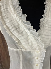 Close-up of Seventy Cotton Vest in white linen, featuring ruffled collar and button details, perfect for summer outfits.