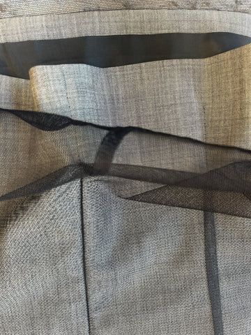 Close-up of textured gray wool fabric layered with black net, showcasing the materials used in the Laurel Vest.