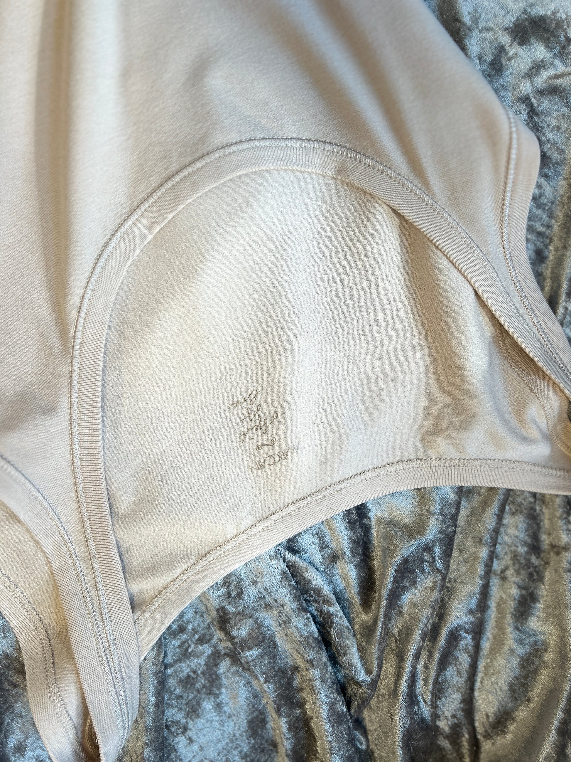 Close-up of Marccain Cotton Vest highlighting its soft fabric and classic design on a plush background.