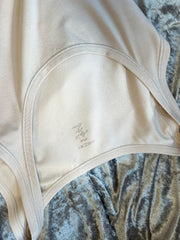 Close-up of Marccain Cotton Vest highlighting its soft fabric and classic design on a plush background.