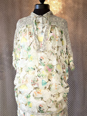 Marccain silk blouse featuring a sheer design with floral patterns and delicate thread detailing, elegantly displayed on a mannequin.