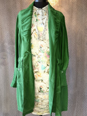 Green long sleeve jacket layered over a floral print dress on a mannequin, showcasing stylish women's fashion.